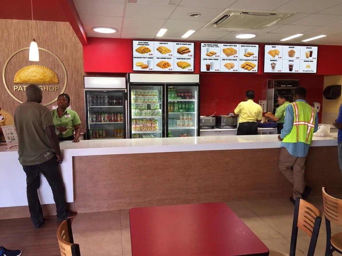 Digital menu boards managed by X-Play above a food court counter